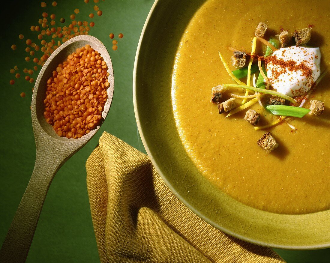 Red lentil soup decorated with crème fraiche and bread cubes
