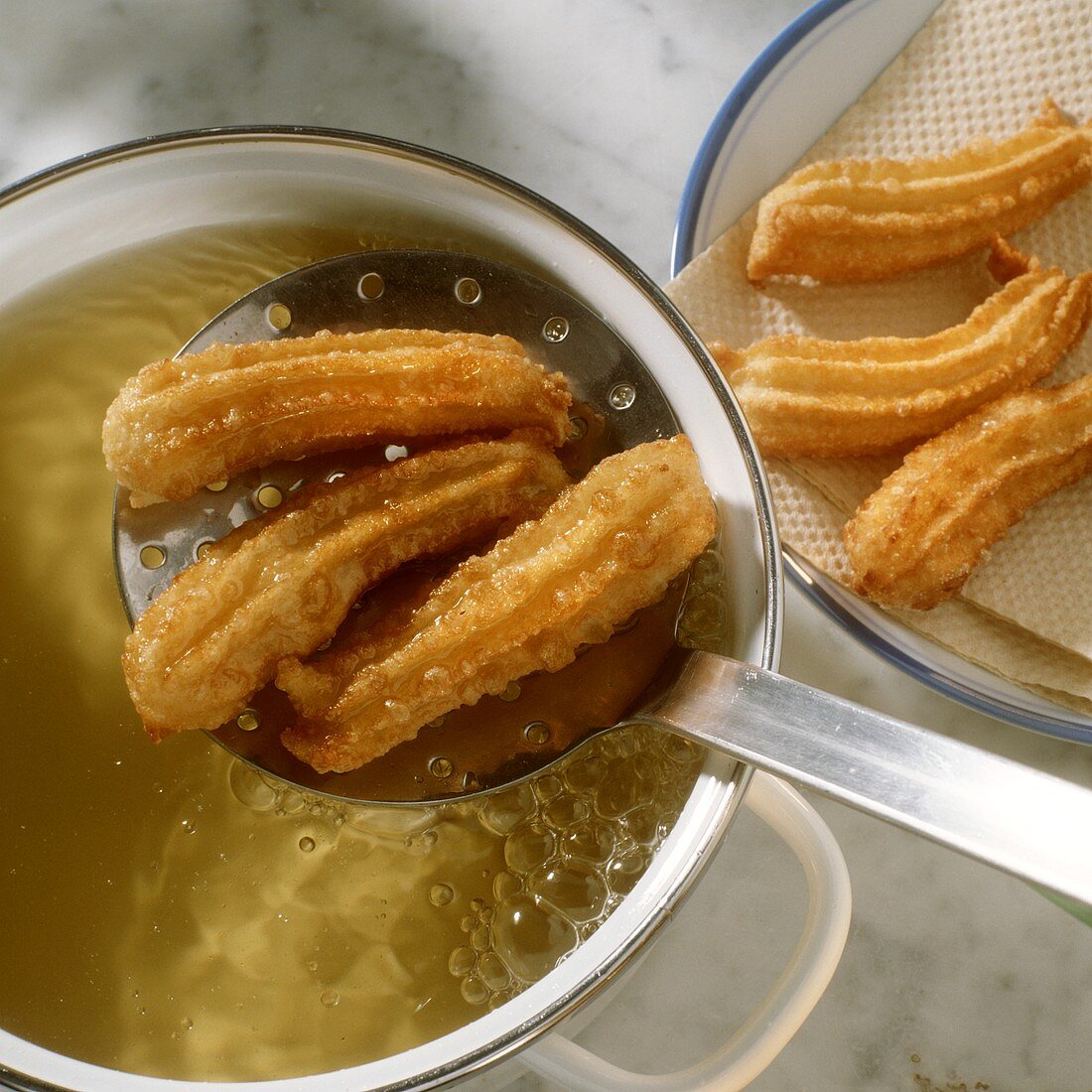 Deep-frying churros (Spanish doughnuts)