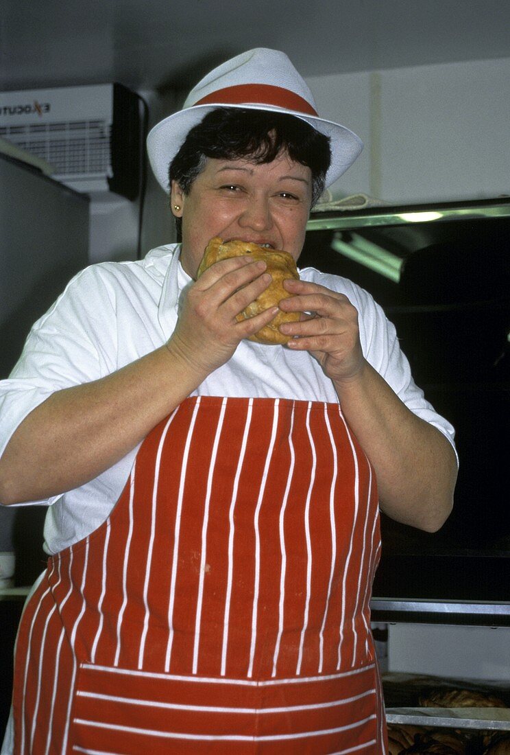 Frau beißt in frische Cornish Pasty (Cornwaller Pastete)