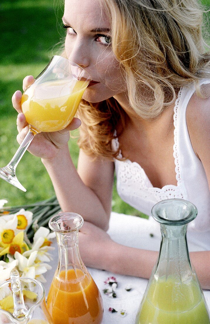 Young woman drinking healthy juices (outdoors)