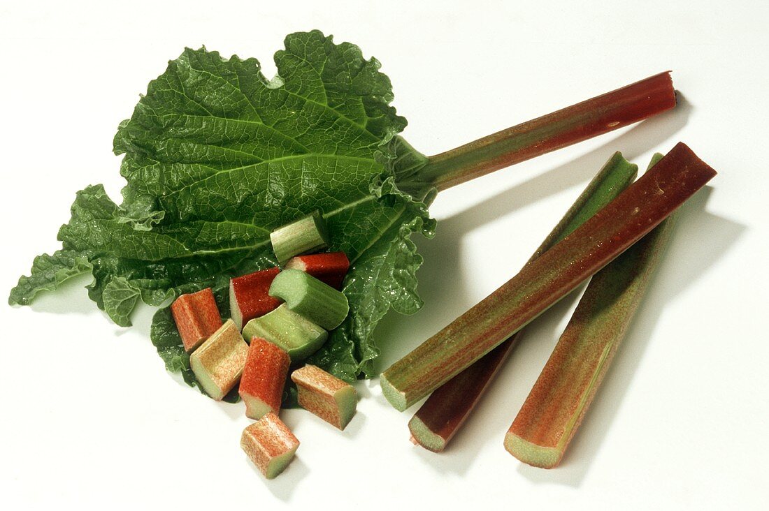 Sticks of rhubarb (one with leaf) and pieces of rhubarb