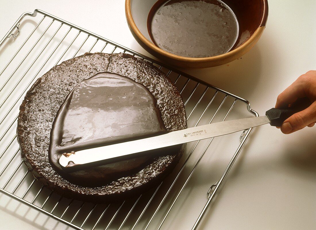 Spreading Sacher torte base with couverture
