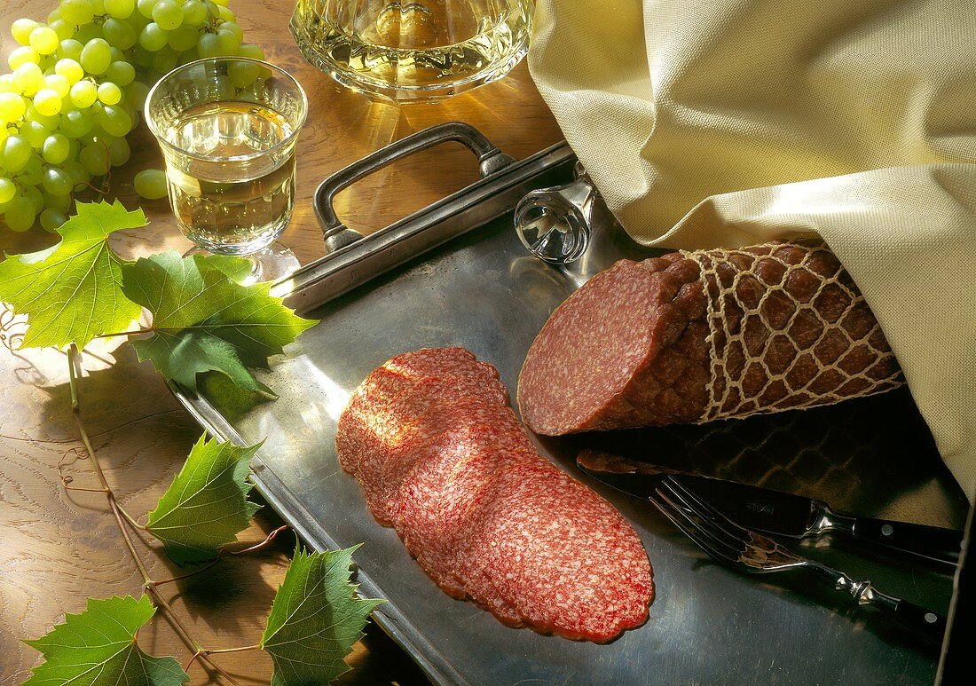 Cervelat sausage with net and in slices on silver tray