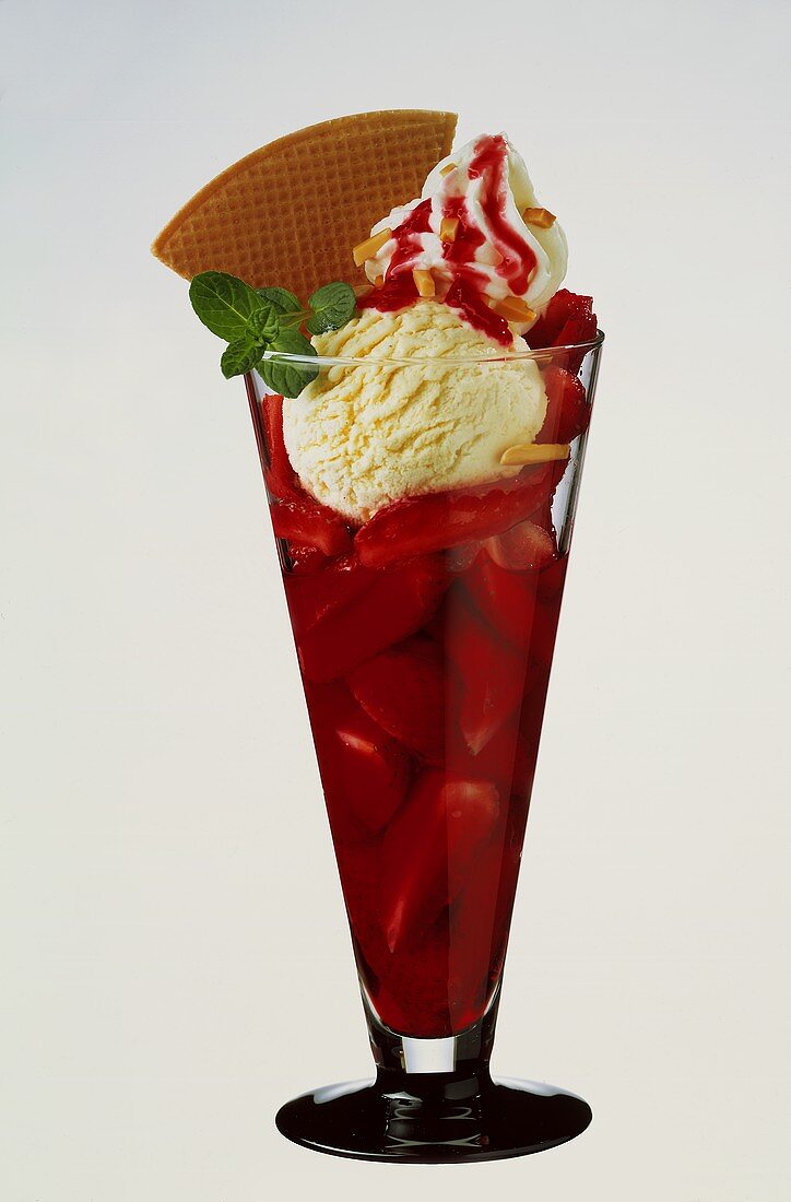 Strawberry ice cream sundae with vanilla ice cream, cream & wafer