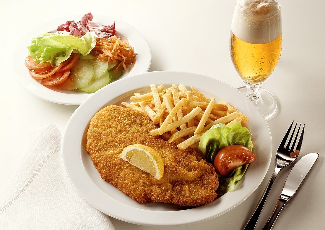 Breaded escalope with chips, salad plate, glass of beer