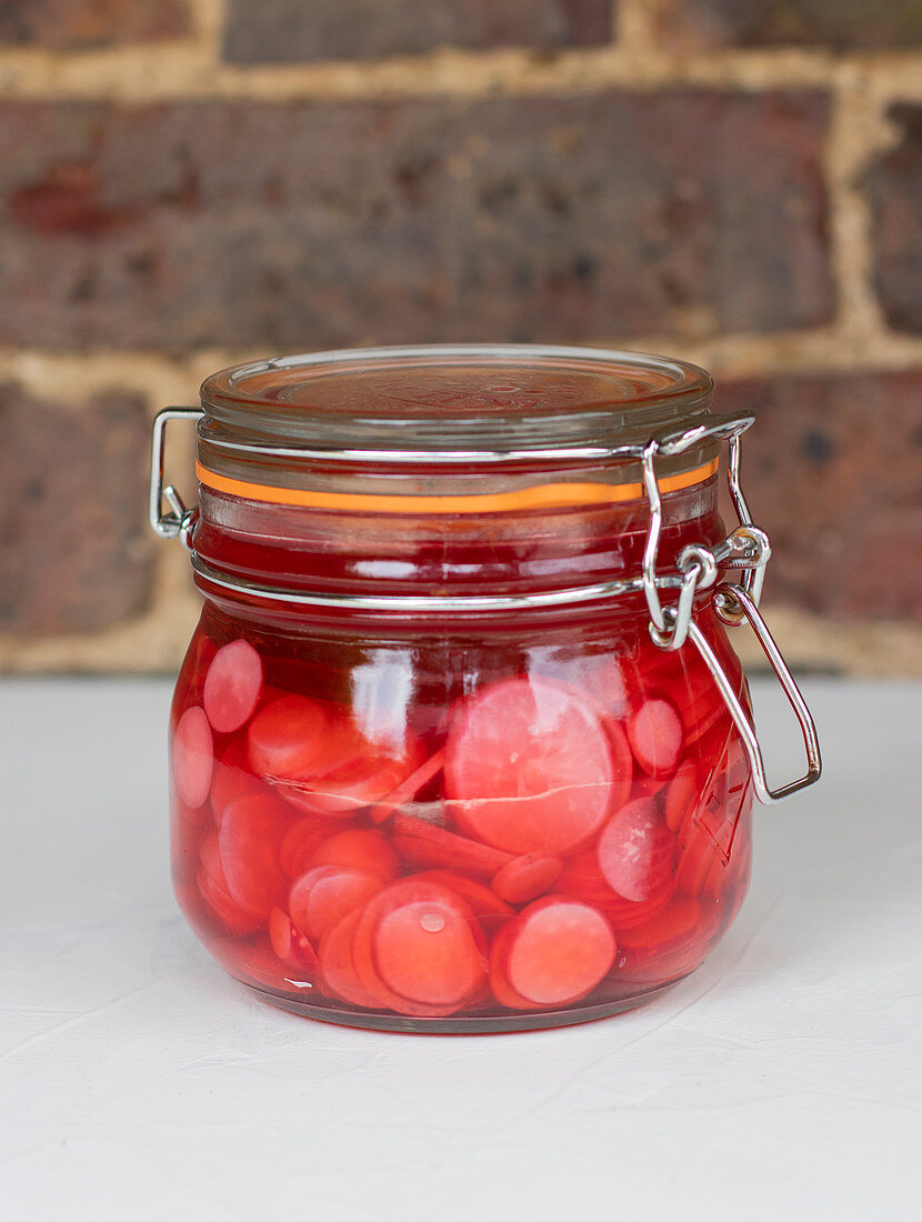 Pickled radishes in a flip-top jar