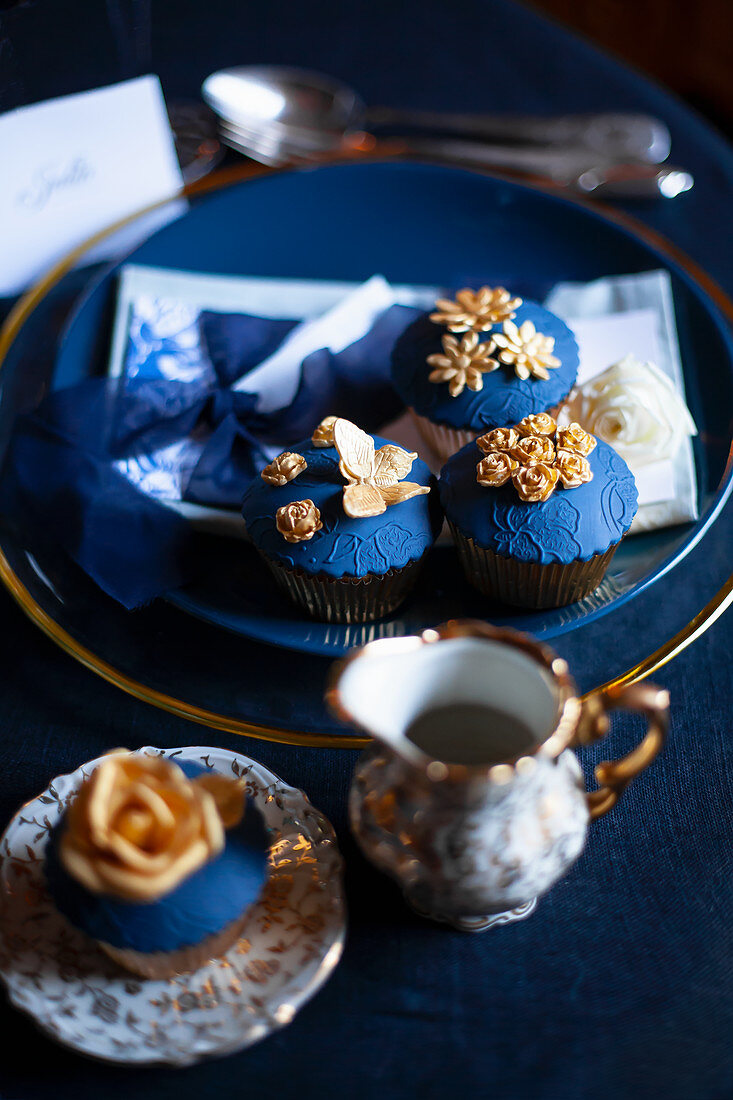 Perfekt dekorierte Cupcakes mit Topping in Dunkelblau und Gold