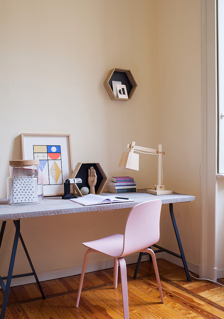 DIY-Schreibtisch mit Dekoration und rosa Stuhl