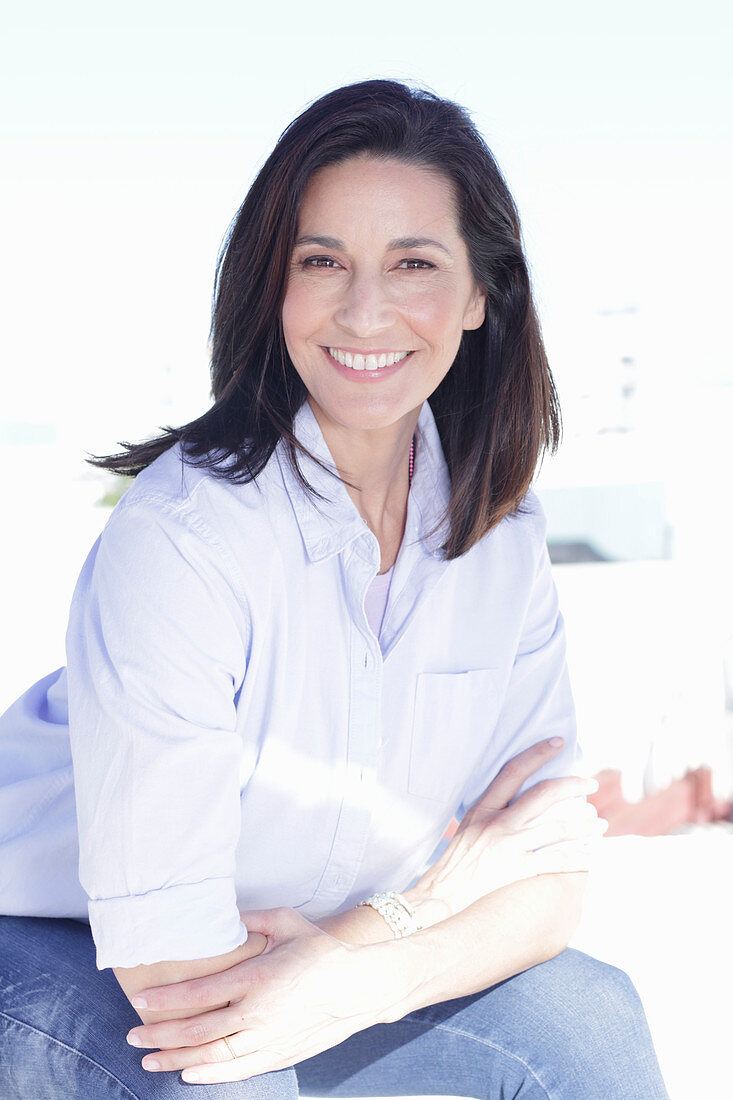 A brunette woman wearing a light shirt and jeans