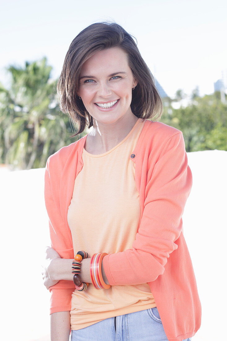 A young woman wearing an apricot top and cardigan