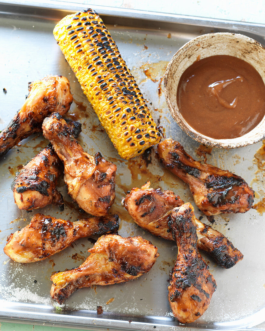 Grilled chicken legs with a corn cob and barbecue sauce