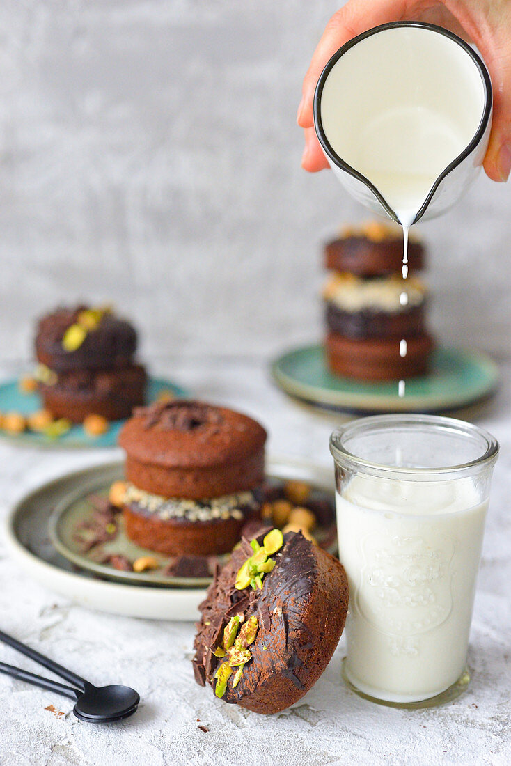 A person pours milk into a glass chocolate muffins