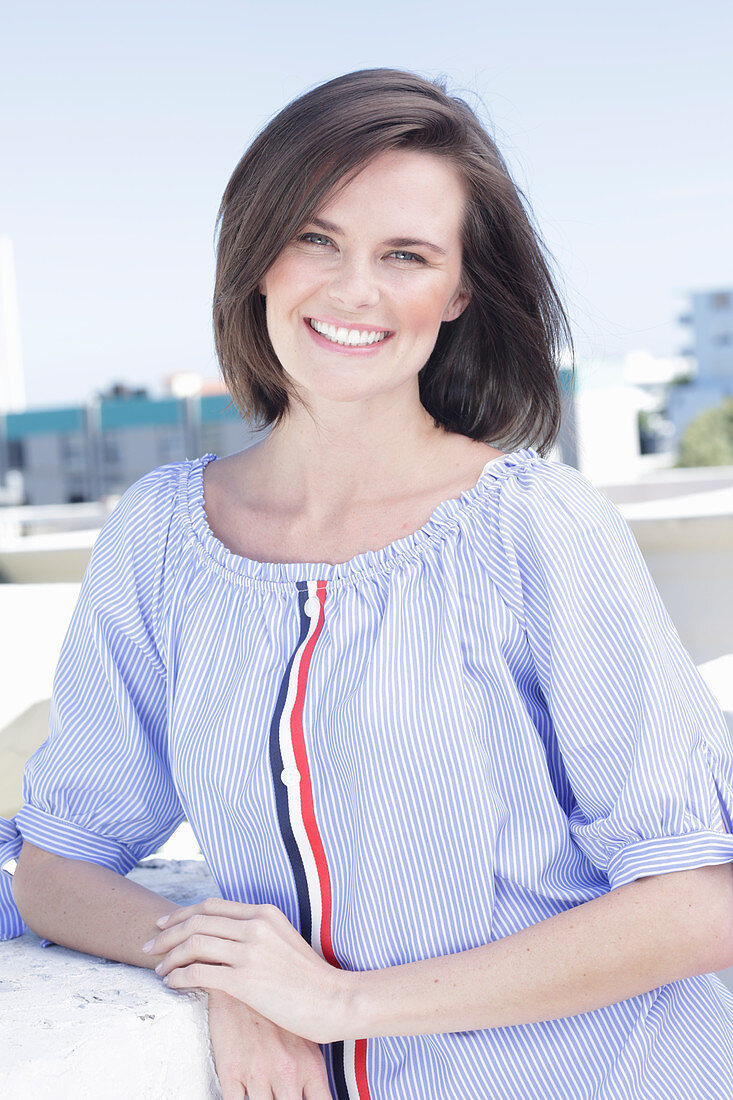 A young woman wearing a blue-and-white striped Carmen blouse