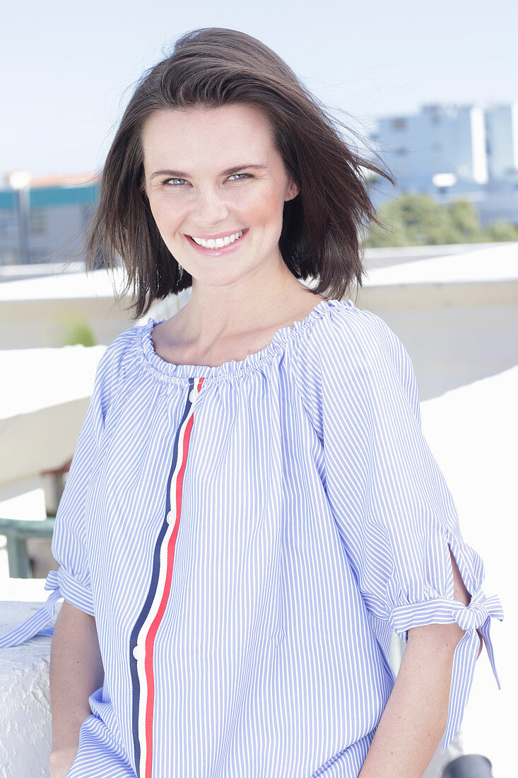 A young woman wearing a blue-and-white striped Carmen blouse