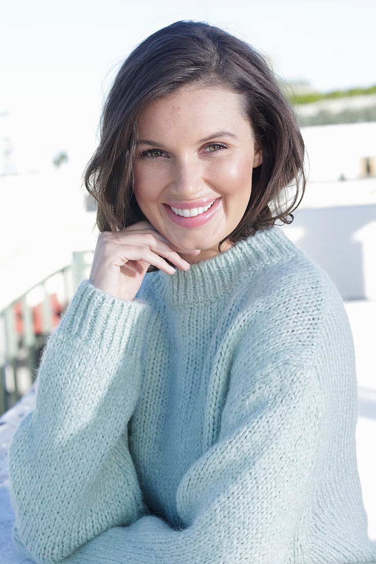 A young woman wearing a light knitted jumper