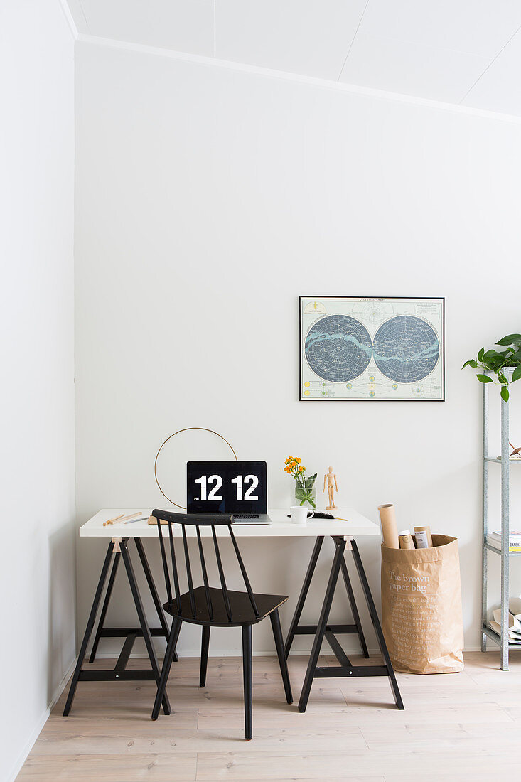 Spoke-back chair at trestle desk with computer showing time