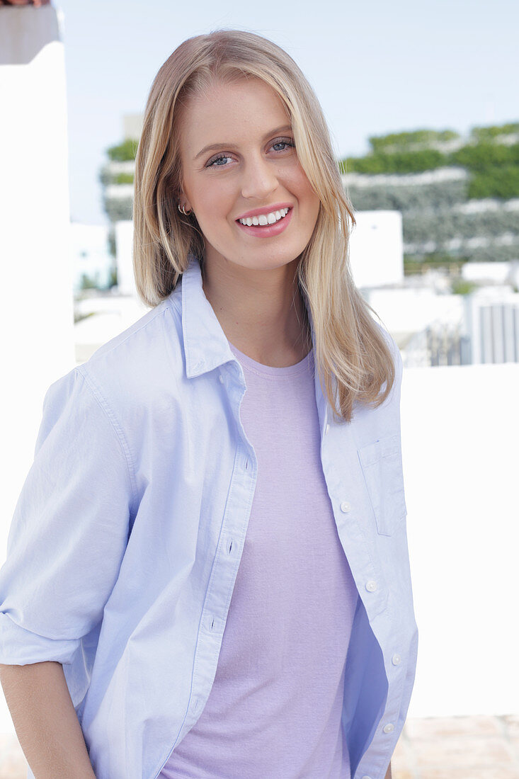 A young blonde woman wearing a purple t-shirt and a shirt