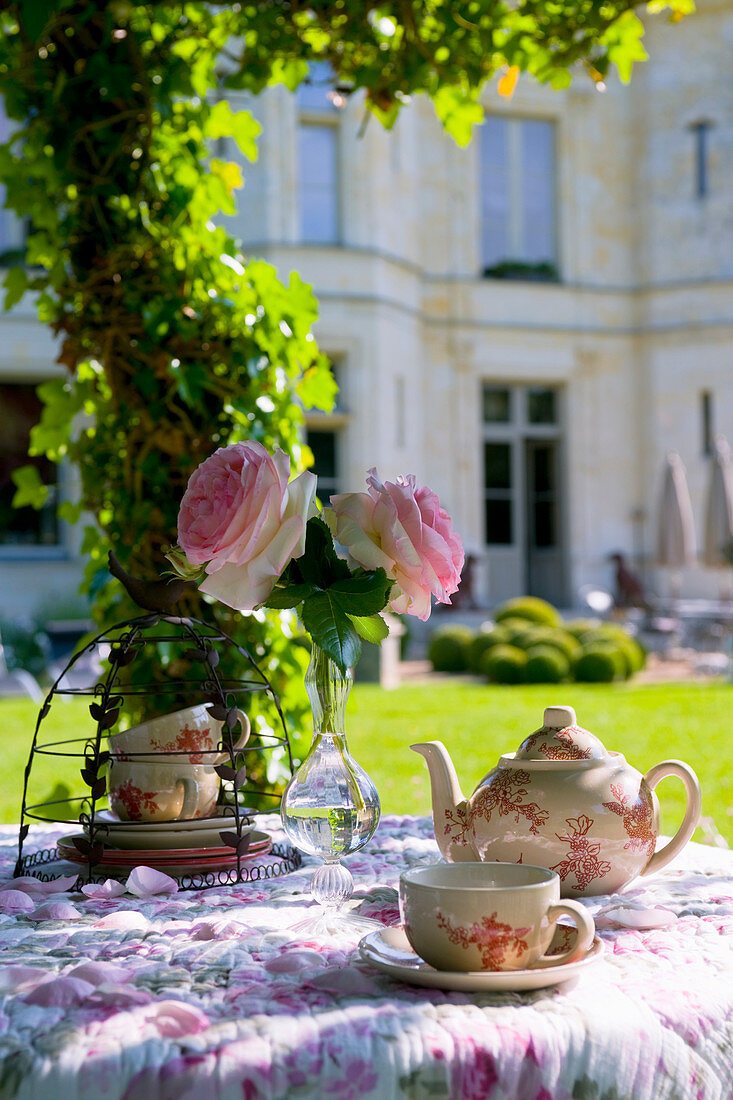 Romantically set tea table in summery château garden