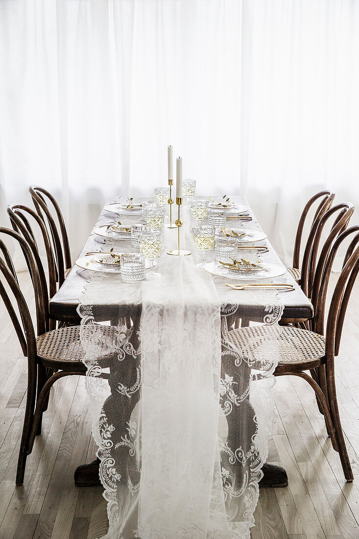 Bistro chairs around table set with lace tablecloth