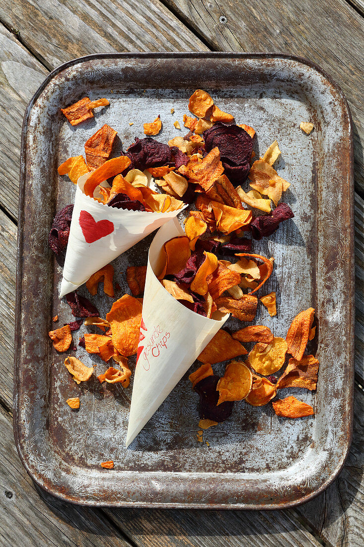 Selbstgemachte Kartoffelchips aus bunten Kartoffeln in Papiertüten