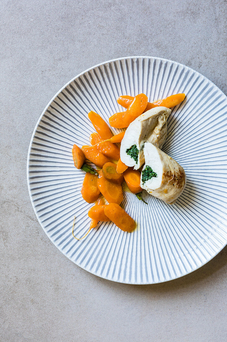 Chicken breast filled with carrot leaf butter on Vichy carrots