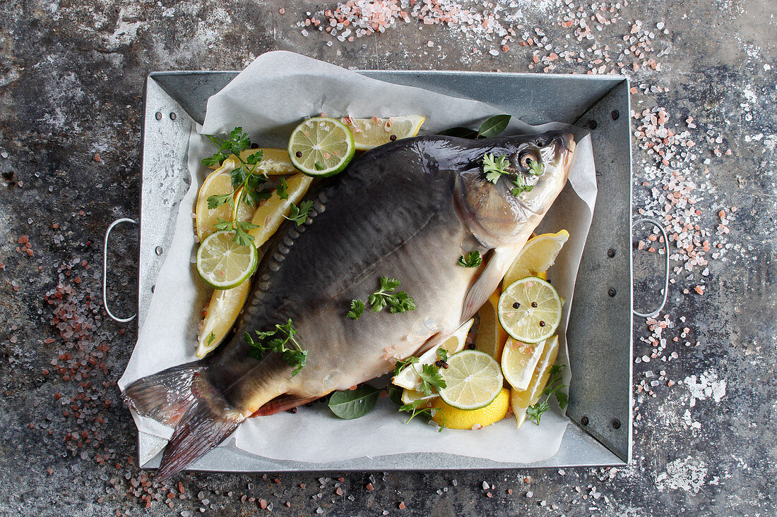 Fresh carp in a dish with lemon and lime