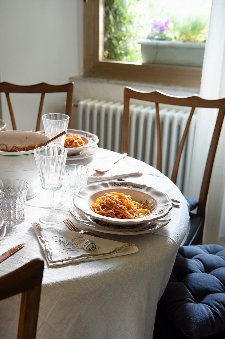 Gedeckter Tisch mit Pasta auf Tellern
