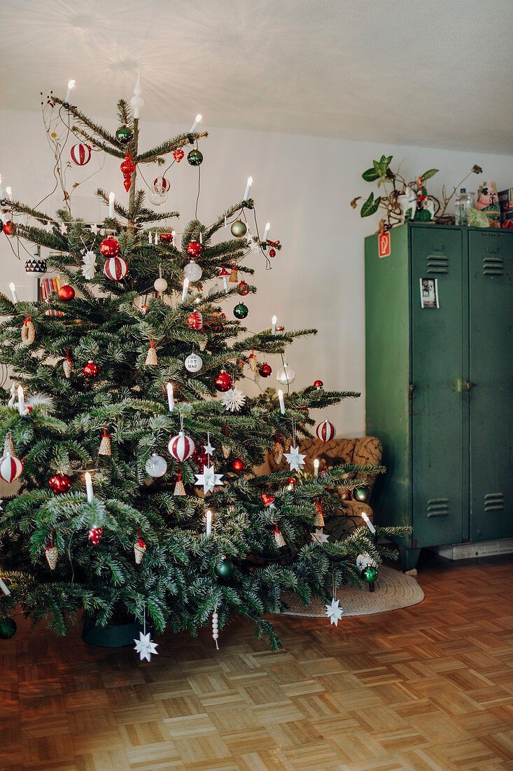 Classic Christmas tree decorated in red and white next to locker