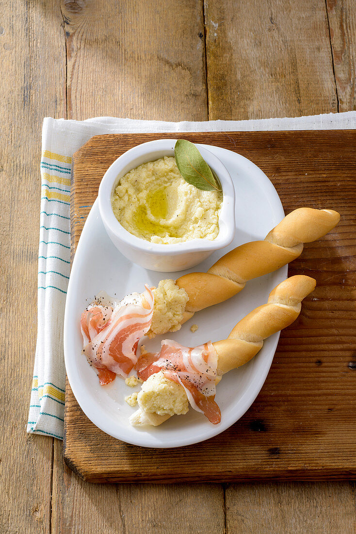 Parmesancreme und Pfeffer-Speck zu knusprigen Brotstangen