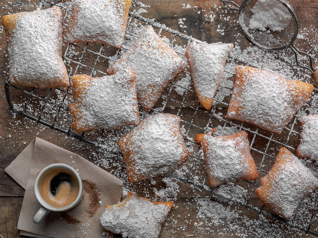 Beignets mit Puderzucker und einer Tasse Espresso