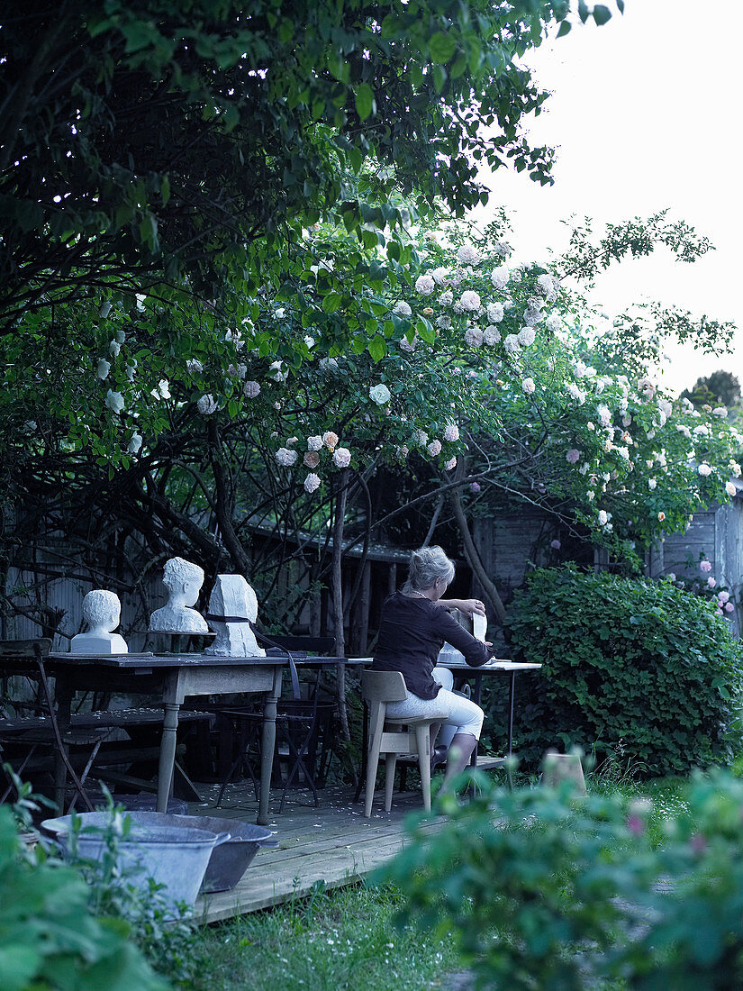 Artist working in shade below climbing rose