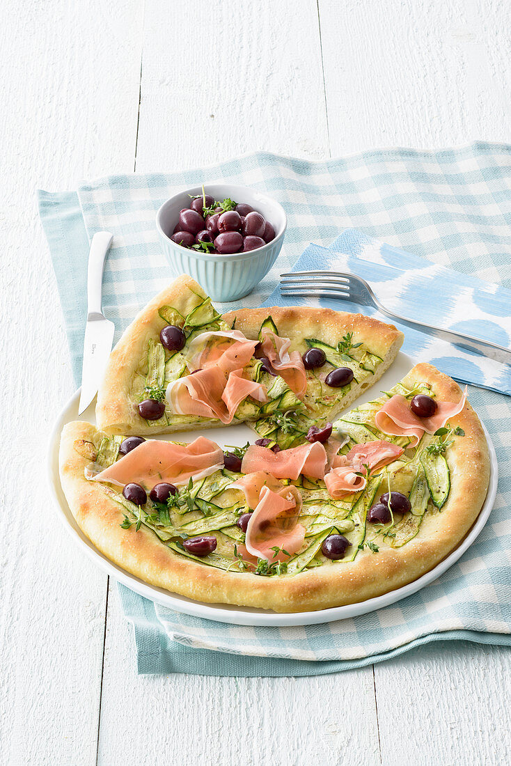Weisse Pizza mit Zucchini, Oliven und Rohschinken