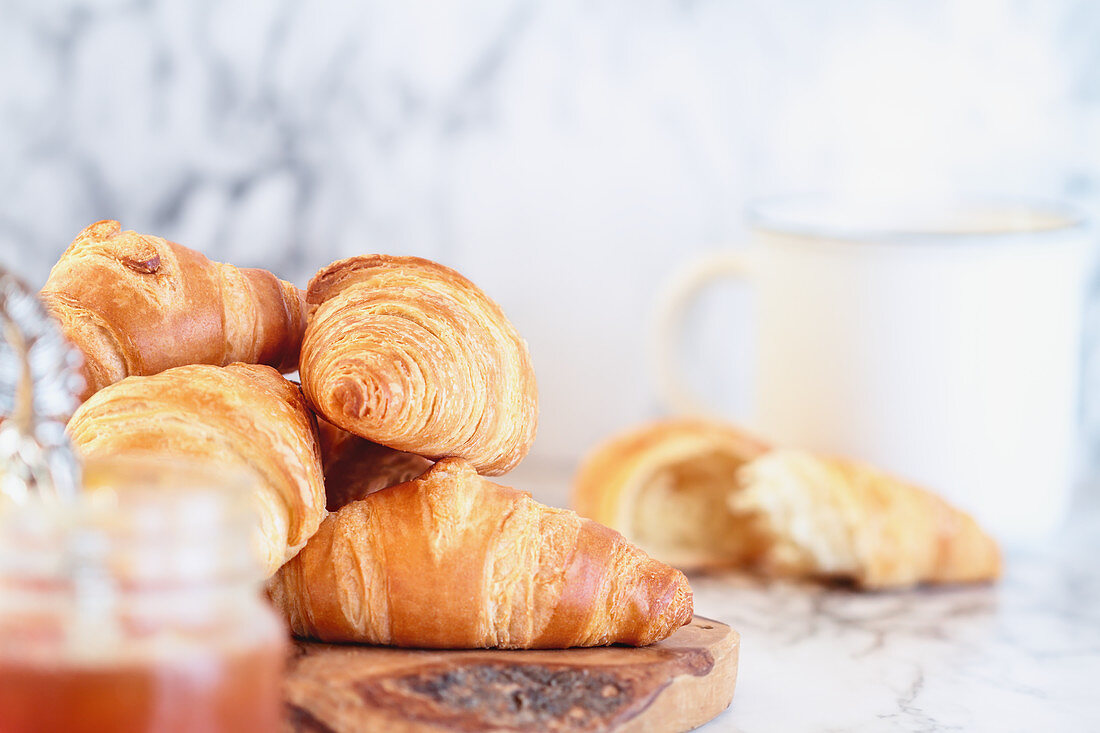 Fresh croissants with preserves and hot coffee