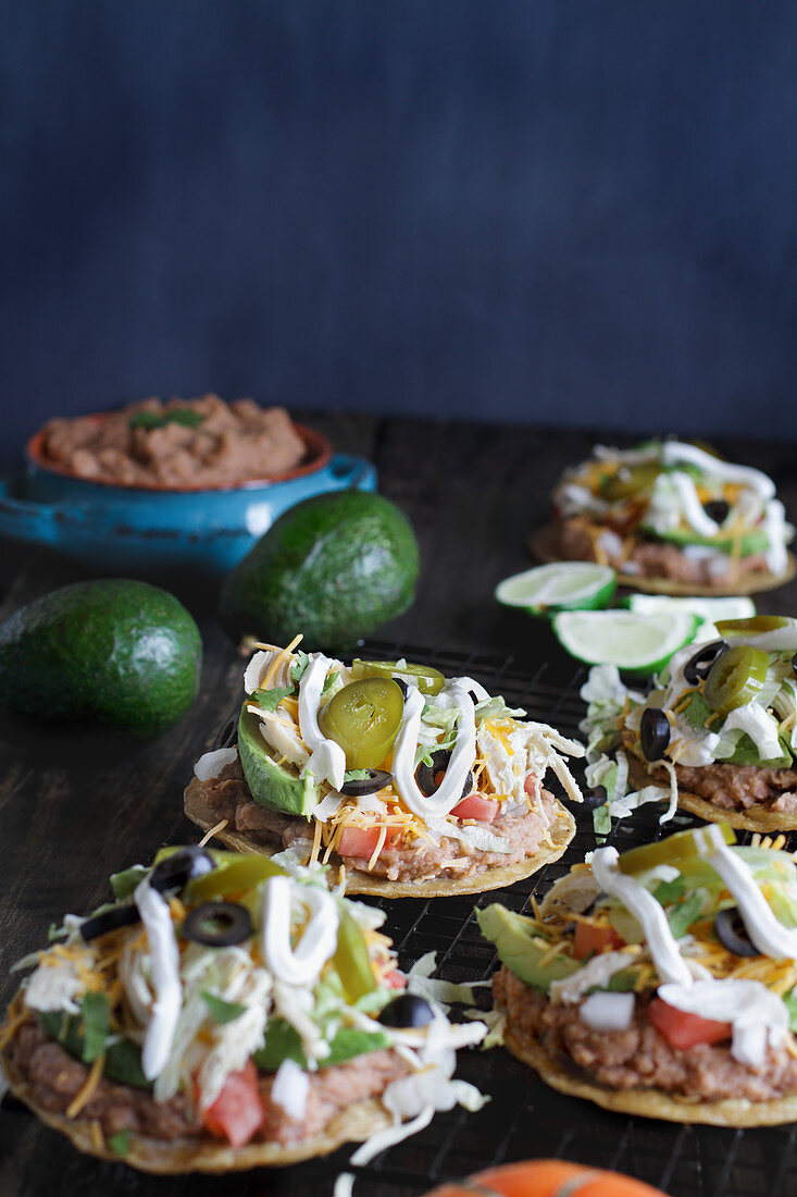 Chicken tostadas with jalapeno peppers, black olives, sour cream, lettuce, shredded chicken and fresh cilantro