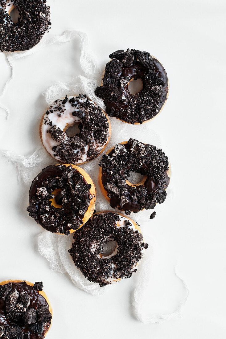 Donuts mit Vanille-Schokoladen-Glasur und Kekskrümeln