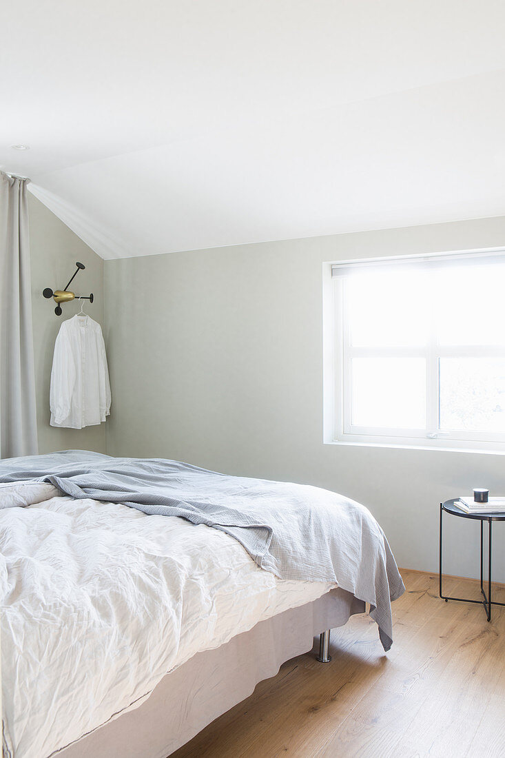 Doppelbett im Schlafzimmer mit hellen Wänden