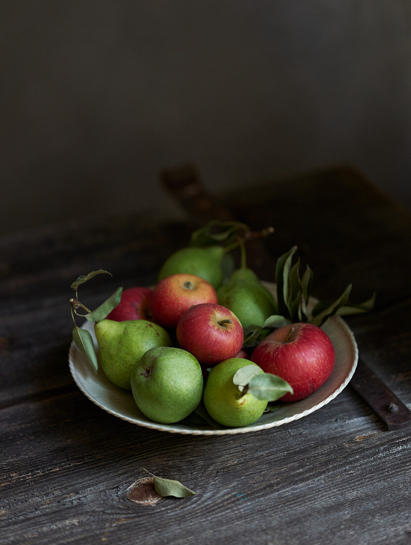 Apples and pears on a rustic wooden table