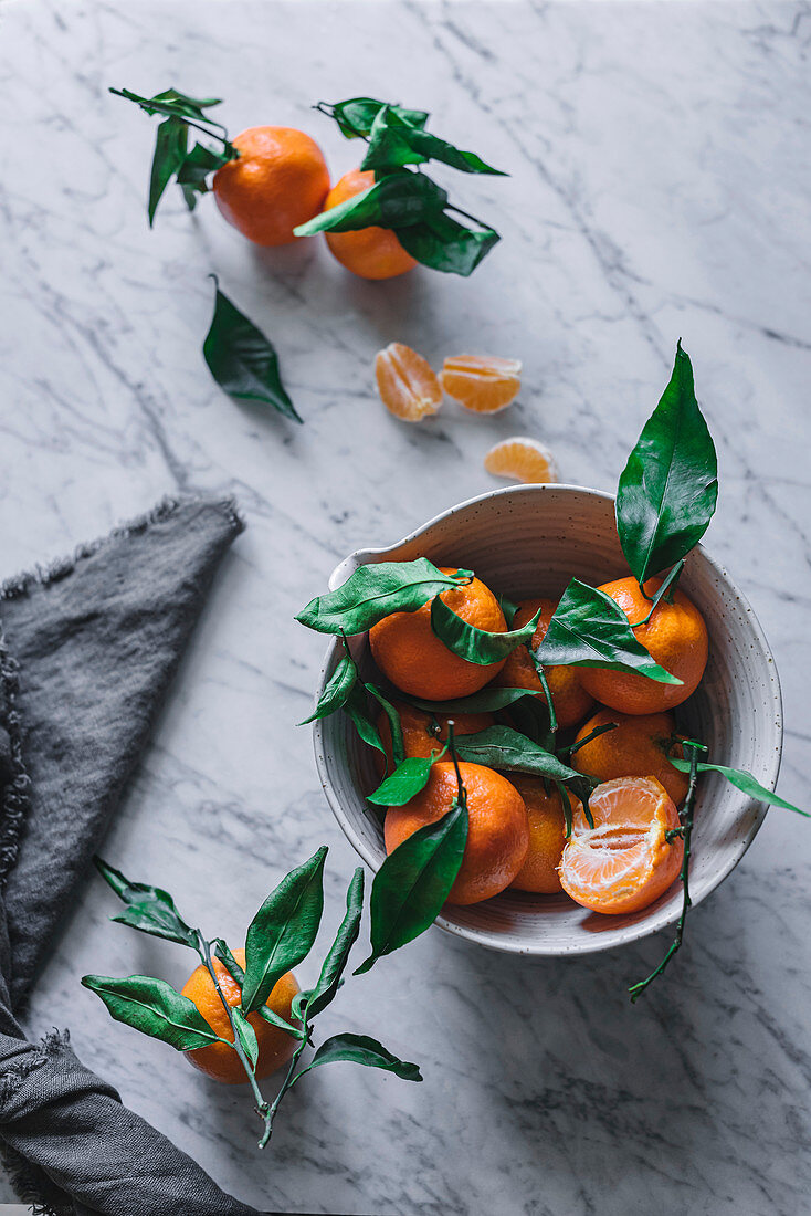 Mandarinen in Keramikschale auf Marmortisch