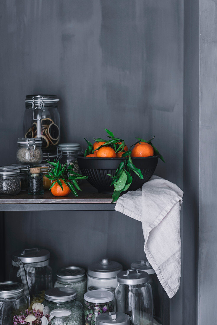 Mandarinen in Keramikschale auf Küchenregal