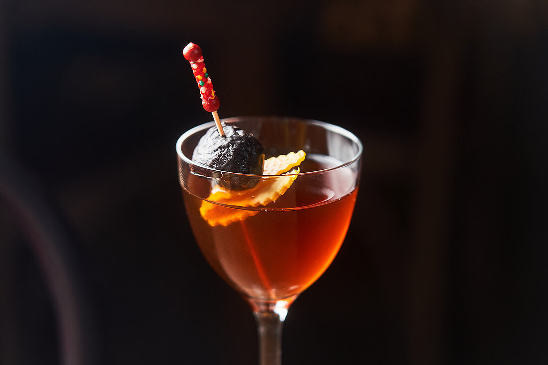 Manhattan-Cocktail mit Kirsche und Orangenschale
