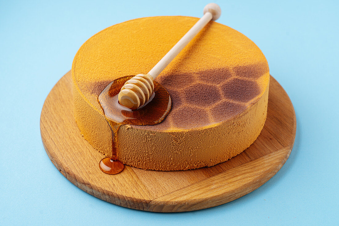Honey spoon on honeycomb cake