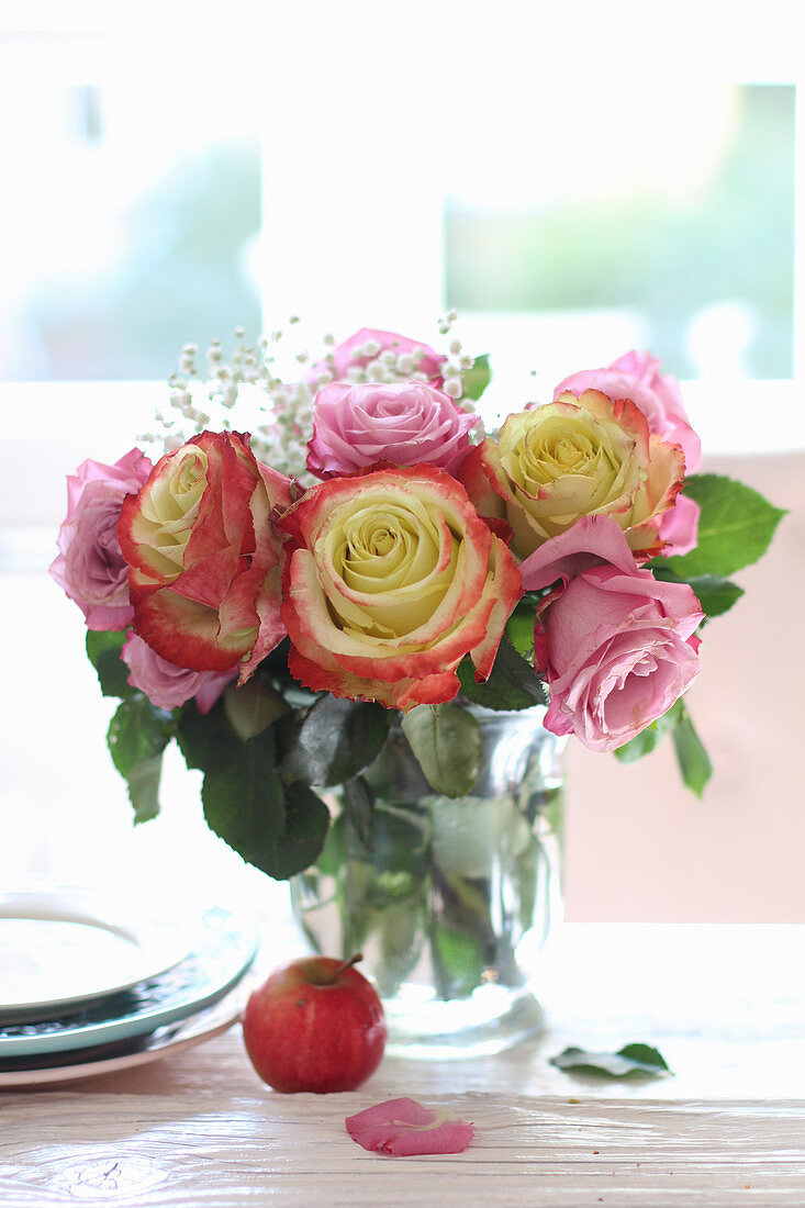 Bouquet of roses and gypsophila in vase on table