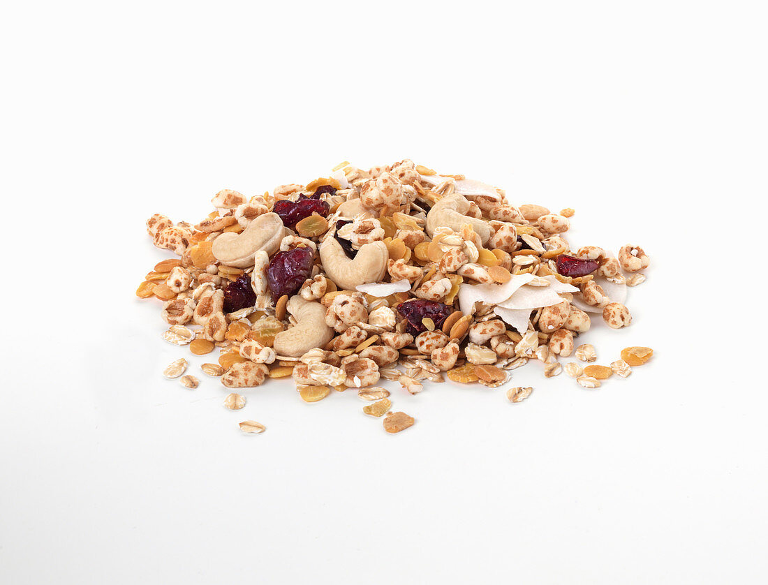 A pile of muesli with dried fruit and nuts on a white background