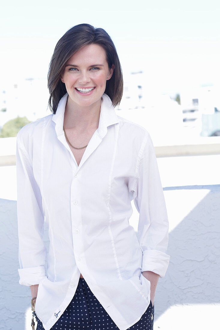 A young woman wearing a white shirt and polka dot trousers