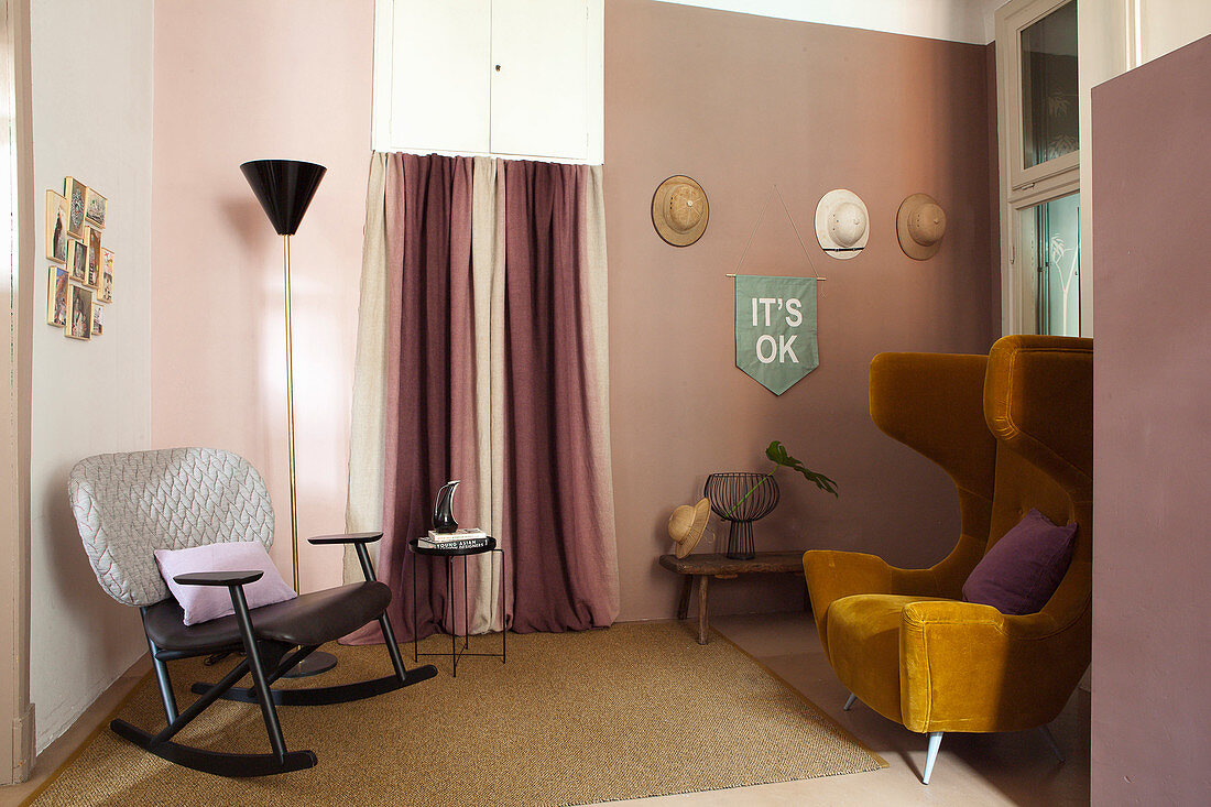 Ochre-yellow wing-back chair and rocking chair in interior decorated in shades of pink