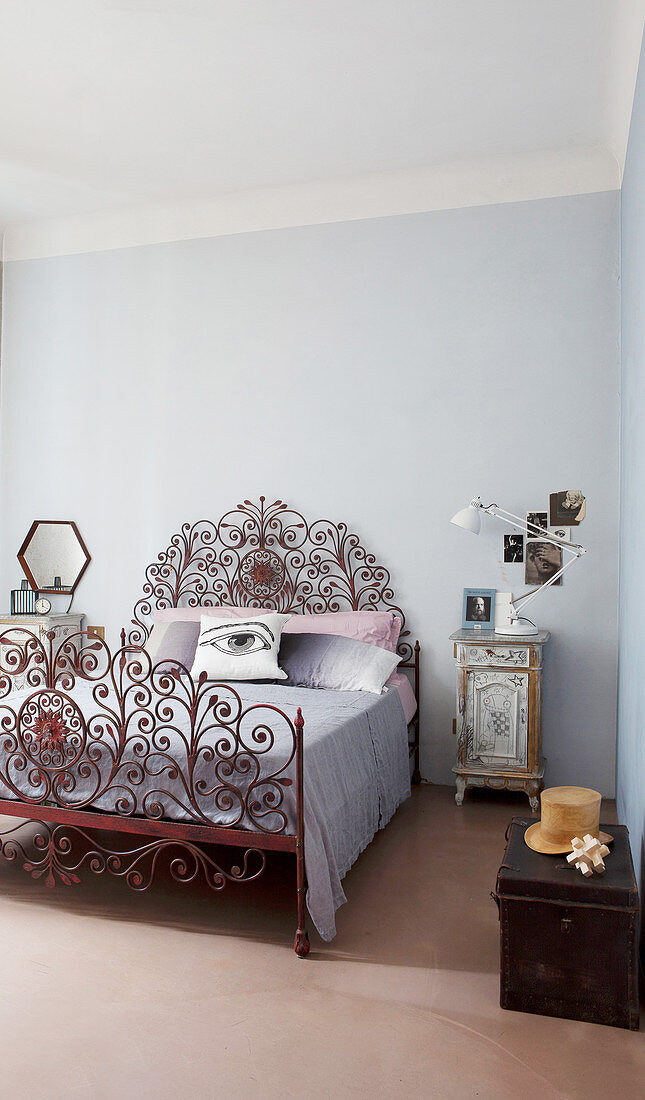 Scatter cushion with hand-painted eye on ornate, red-brown metal bed