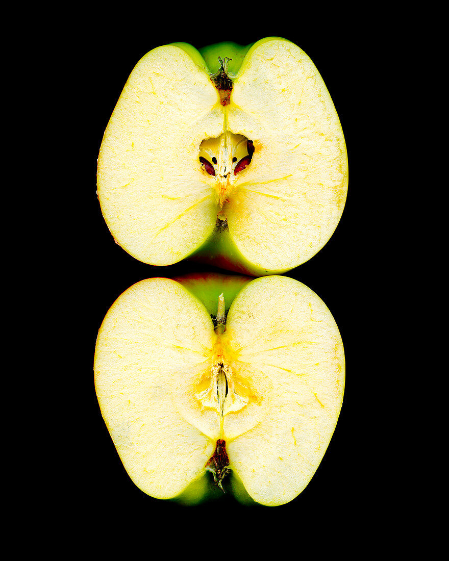 Zwei Apfelhälften vor schwarzem Hintergrund