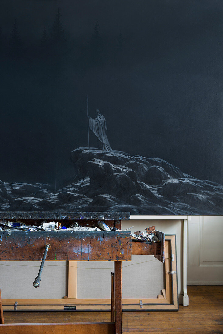 Dark painting on easel in artist's studio