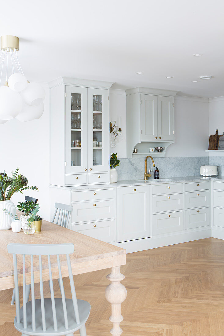 Kitchen-dining room in Scandinavian country-house style with pale grey cabinets