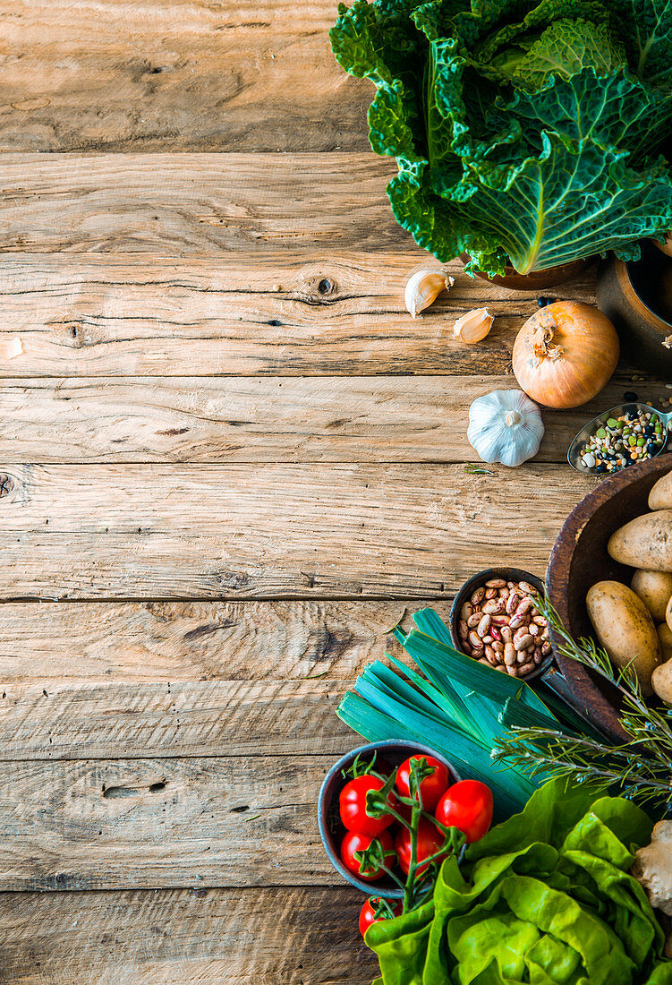 Gemüse, Hülsenfrüchte, Kräuter und Gewürze auf Holzuntergrund